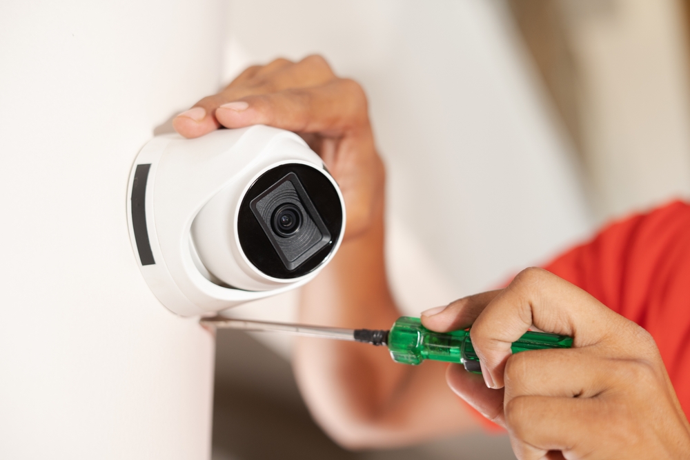 Technician installing a PoE security camera in Mississauga